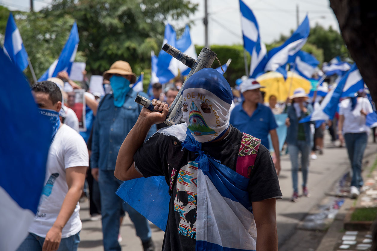 A pesar del asedio, los manifestante siguieron su cometido a eso de las 10: 20 a.m. Iban por las calles alzando banderas y gritando consignas. "No tenemos miedo" "De que se van, se van", decían en coro. Foto: Carlos Herrera | Niú